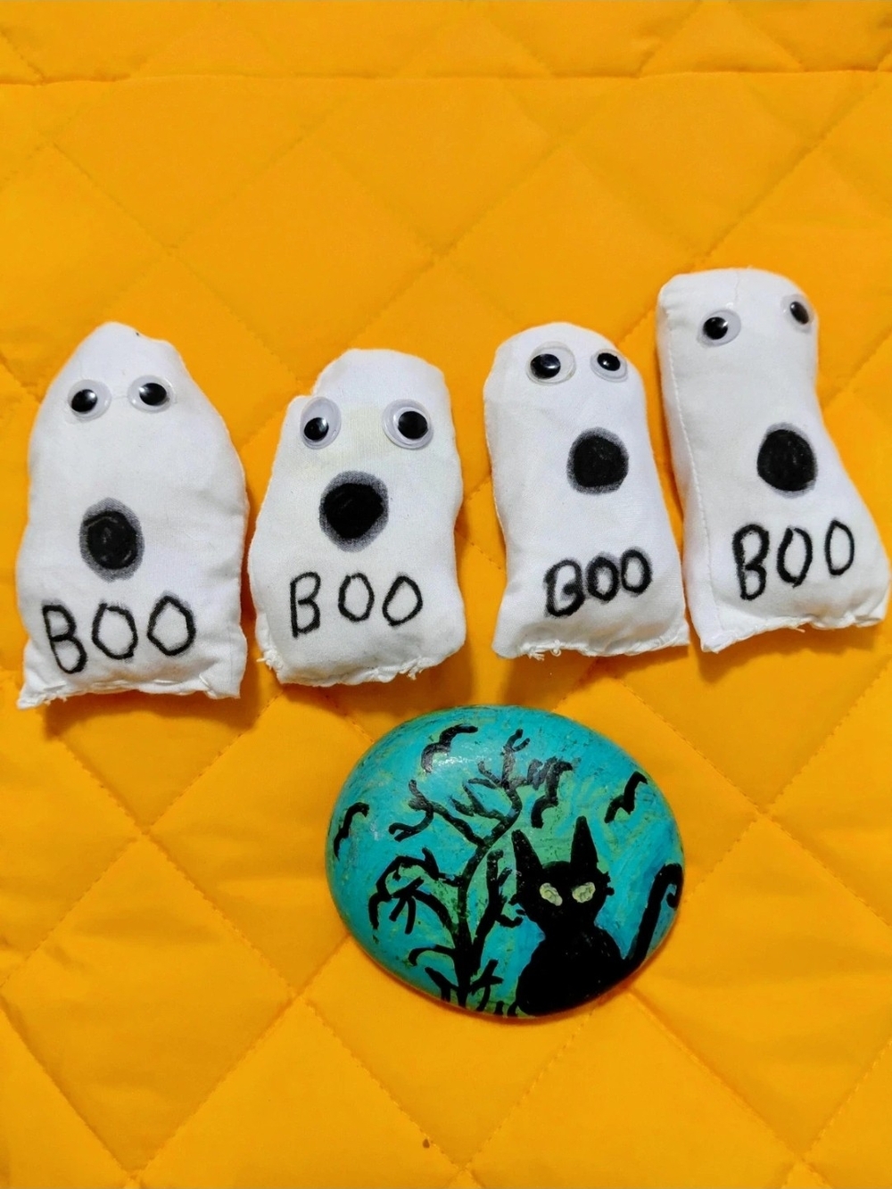 4 baby ghosts and painted haunted cat on stone